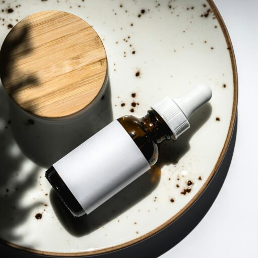 Elegant flatlay of a skincare essential dropper bottle on a ceramic plate. Perfect for product branding and beauty blogs.